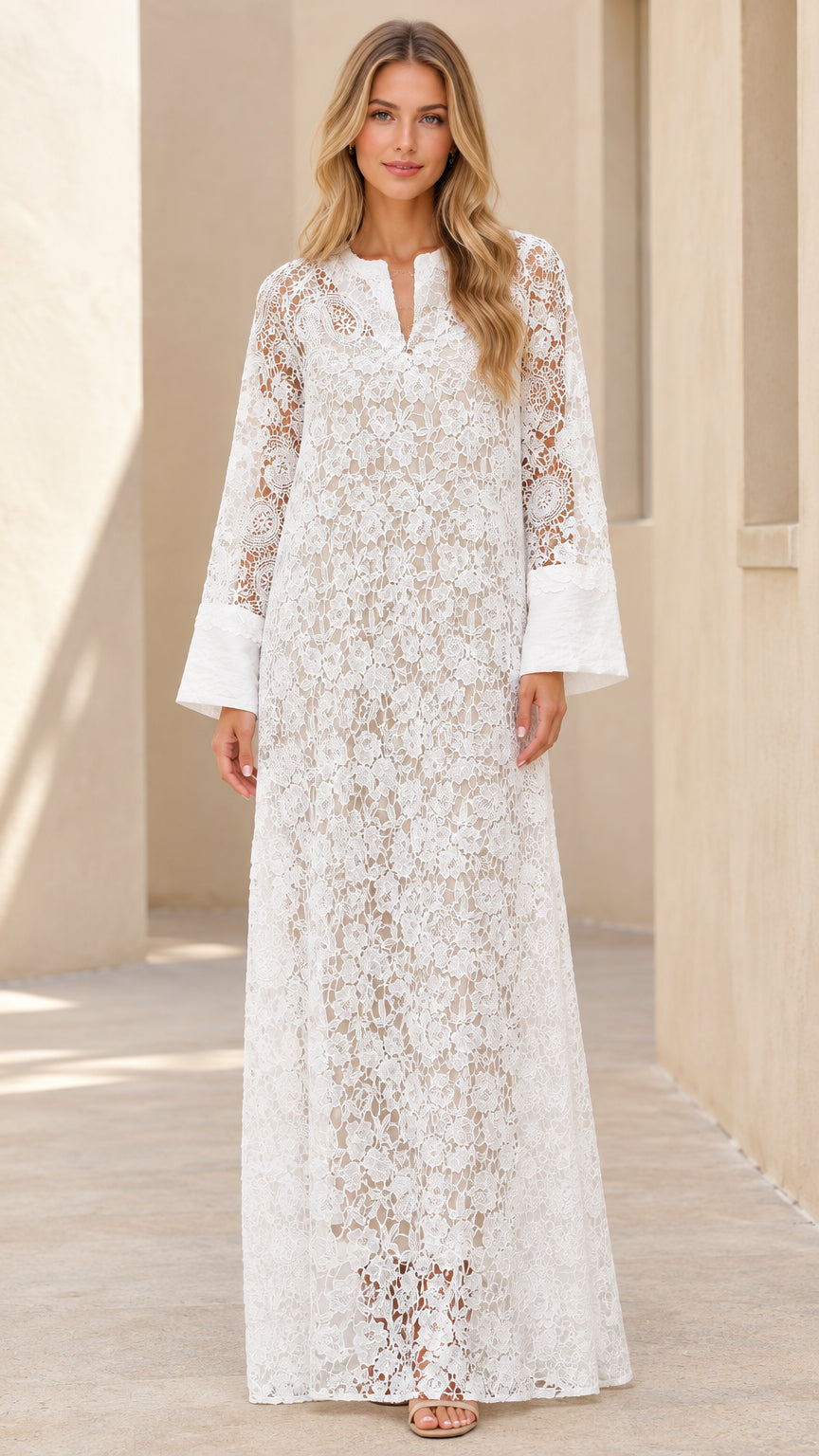 Front view of woman wearing white floral lace split neck maxi dress with wide cuffs