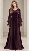 Front view of woman wearing burgundy velvet maxi evening gown with sheer bishop sleeves