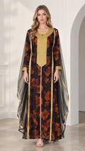 Front view of model wearing black floral kaftan maxi dress with gold embroidered neckline and sheer cape sleeves