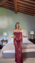 Front view of model wearing burgundy off-the-shoulder sequin corset evening gown with beaded fringe