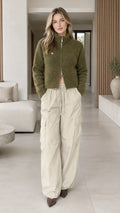 Front full-length view of model wearing olive green textured fleece zip jacket with wide-leg pants