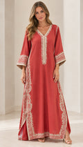 Front full view of woman wearing rust red embroidered kaftan maxi dress