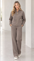 Front view of model wearing taupe zip-up fleece jacket and wide-leg sweatpants set