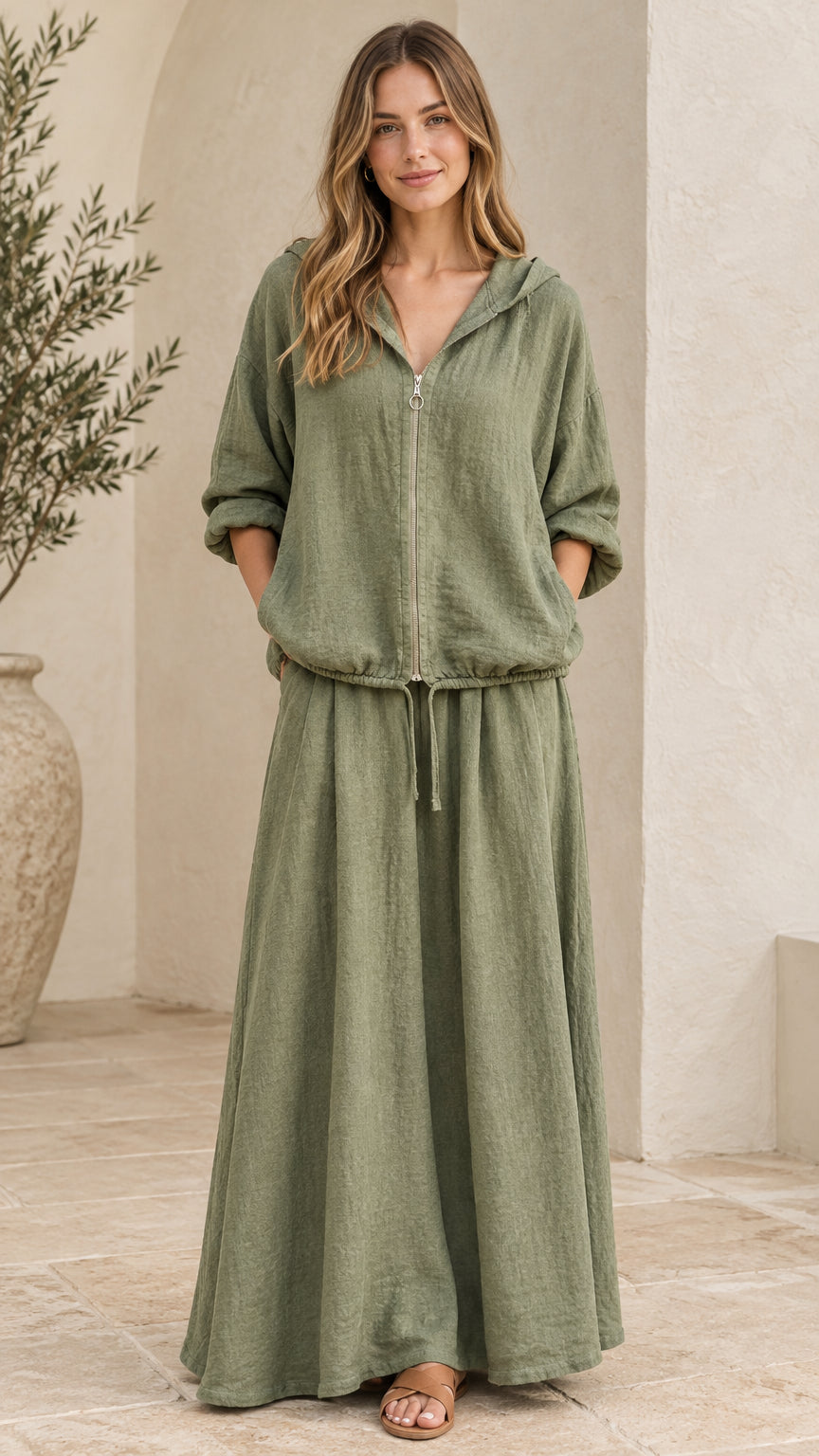 Front view of woman wearing sage green hooded zip-up top and matching maxi skirt set