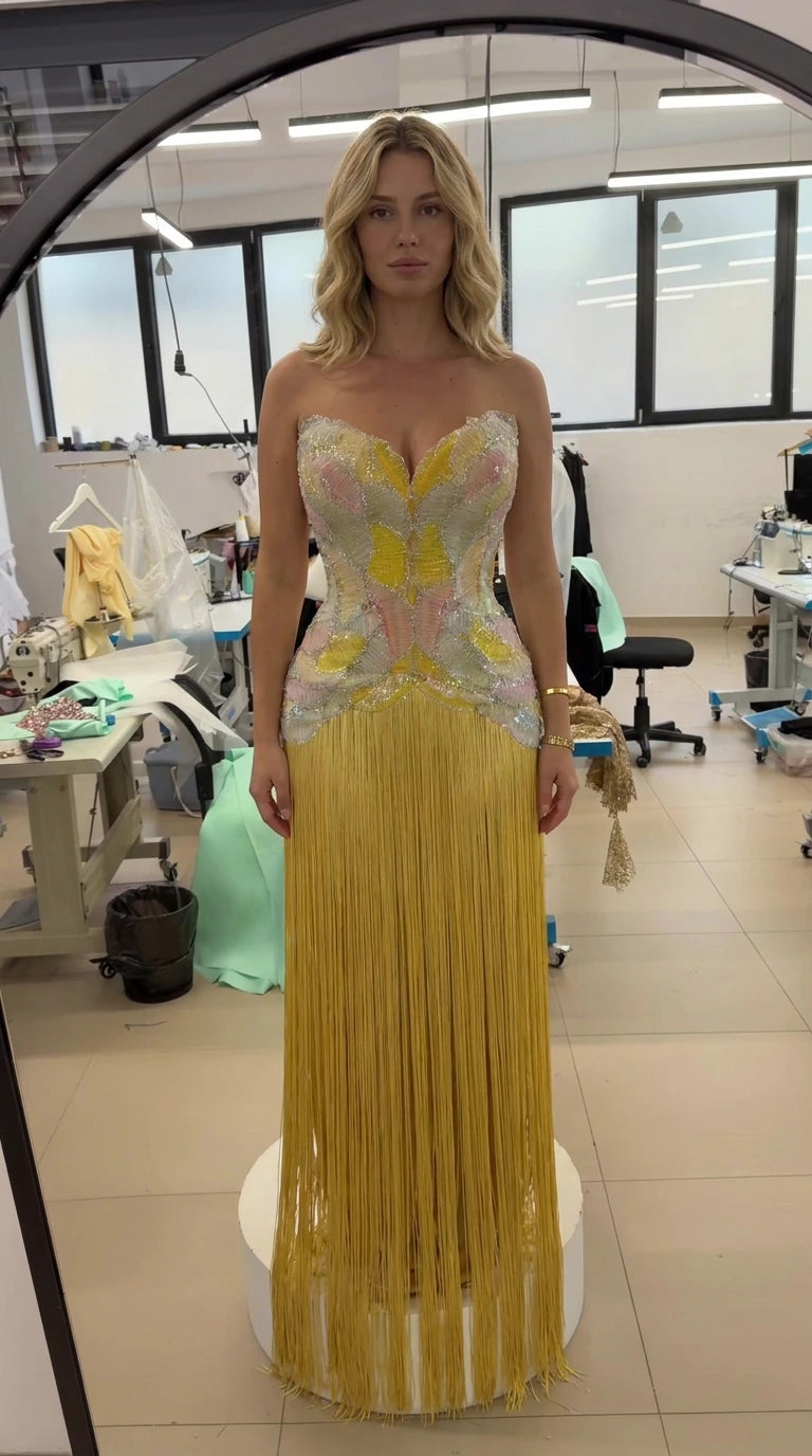 Front view of model wearing the strapless beaded corset fringe gown in yellow