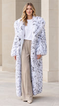 Front view of model wearing full-length snow white speckled faux fur coat