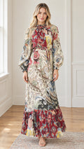 Front view of woman wearing long sleeve floral tiered maxi dress in burgundy multi