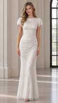 Front view of model wearing a white sequin mock neck floor-length evening gown with cap sleeves