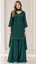 Front view of woman wearing emerald green embroidered tunic with wide-leg pants and matching scarf