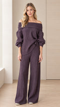 Front view of model wearing dark plum off-the-shoulder textured knit top and wide leg pants set