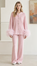 Front full view of woman wearing pastel pink ribbed knit two-piece set with feather cuffs