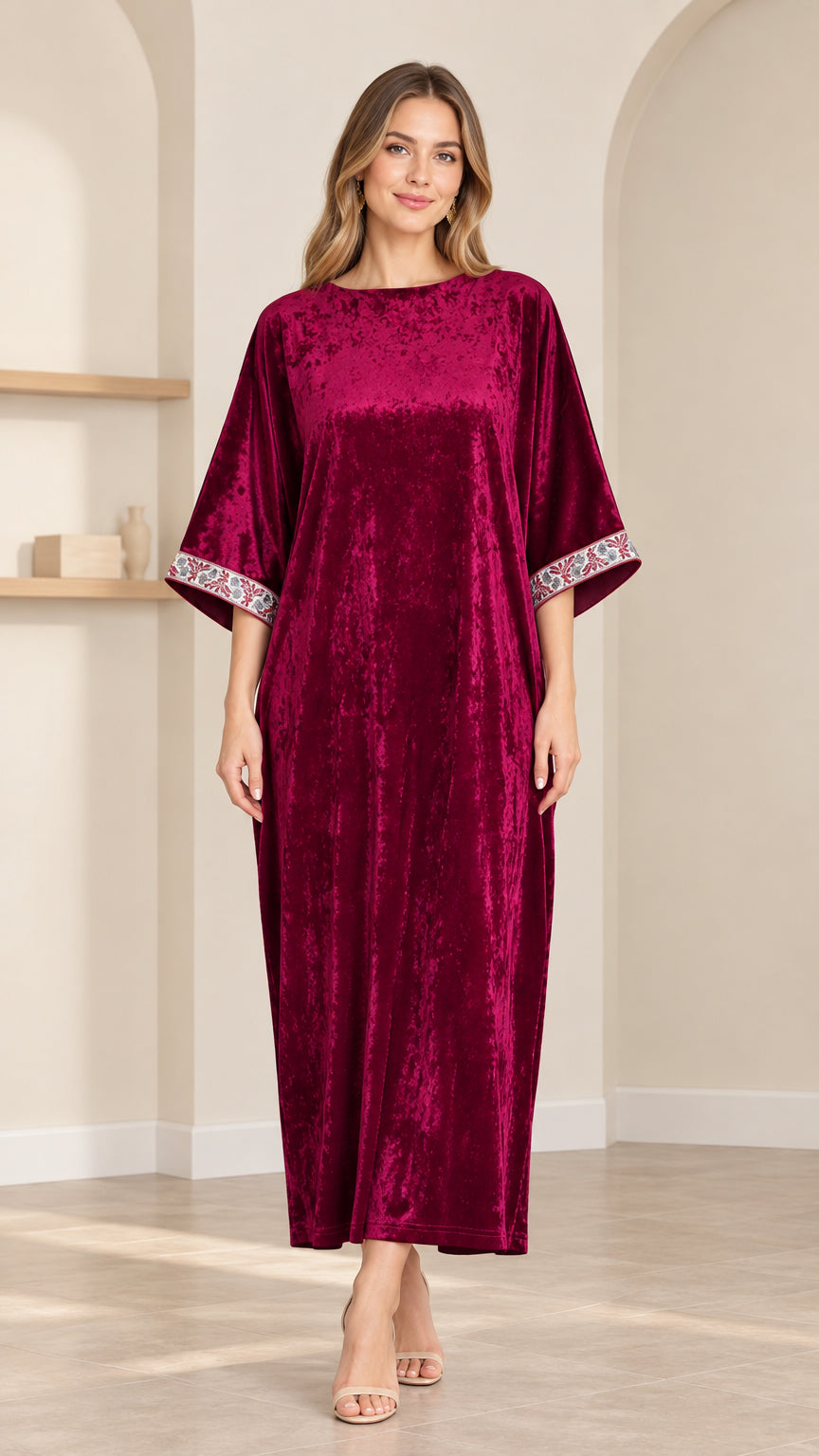 Full front view of model wearing burgundy crushed velvet kaftan maxi dress with embroidered cuffs