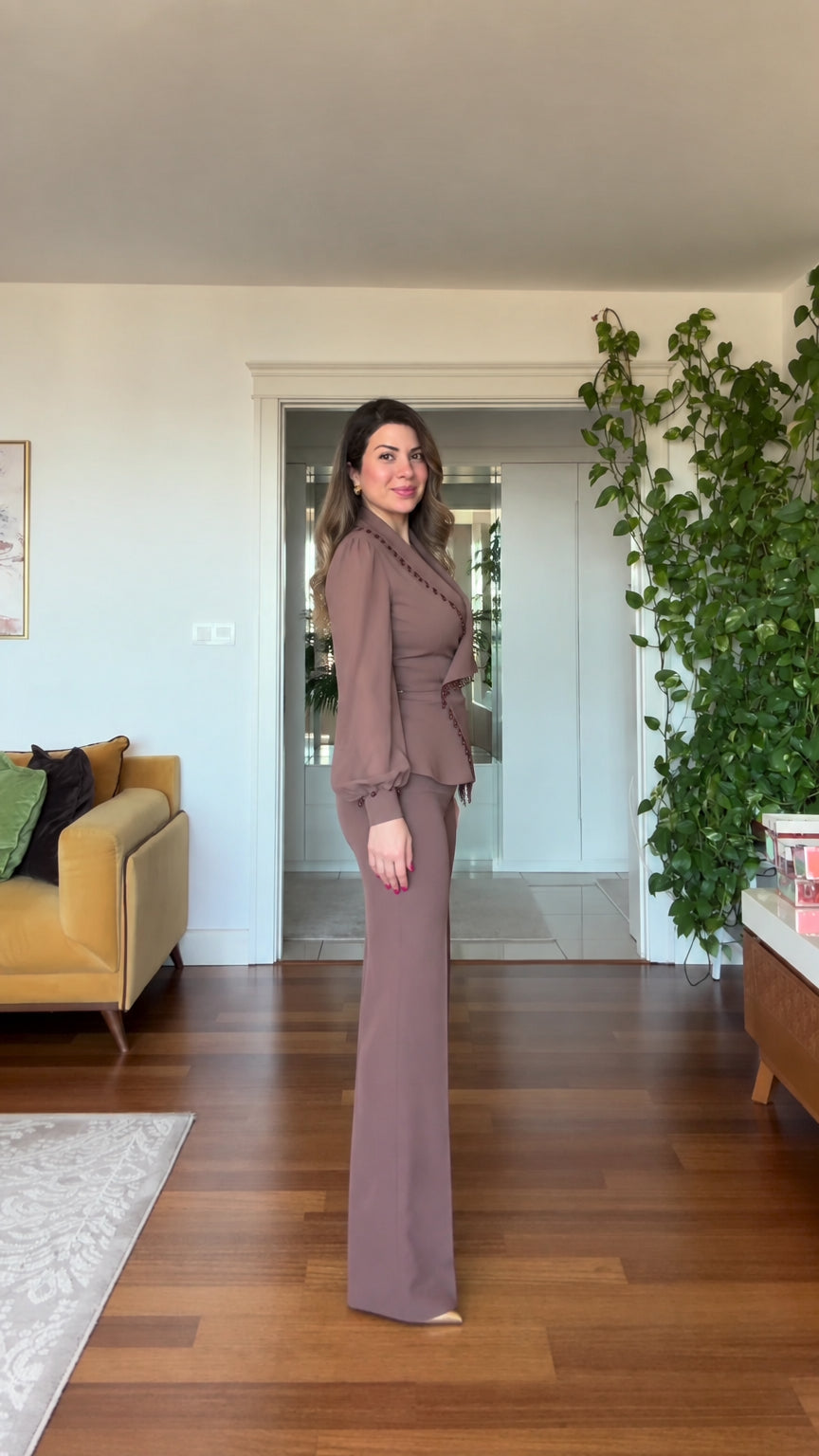 Side profile view of woman wearing mauve tailored two-piece pantsuit