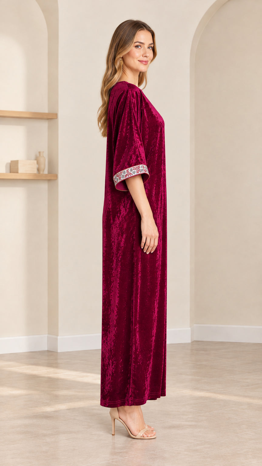 Side profile view of model in burgundy velvet kaftan dress