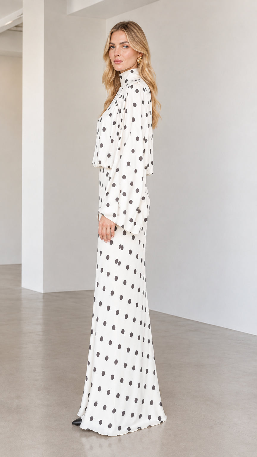 Side profile of model wearing white polka dot long sleeve column maxi dress
