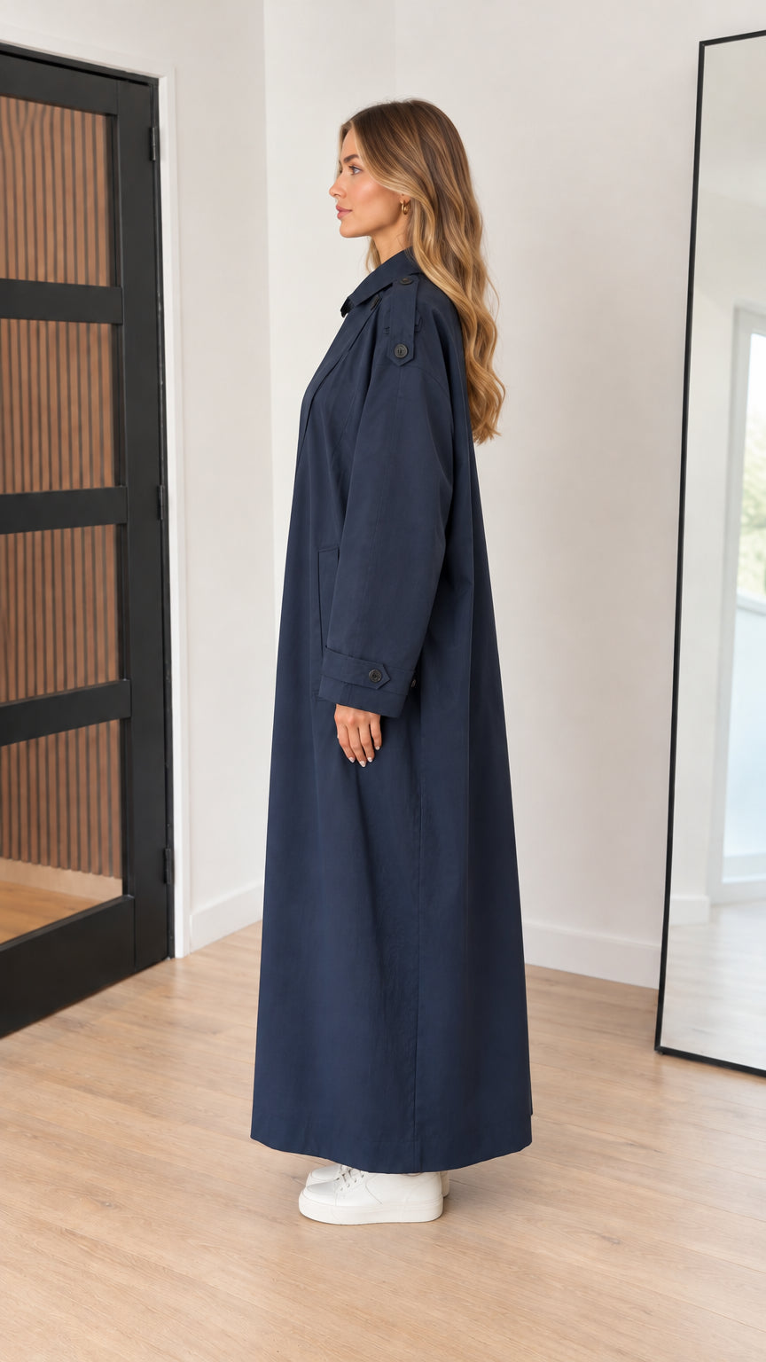 Side profile view of woman modeling navy blue longline trench duster coat