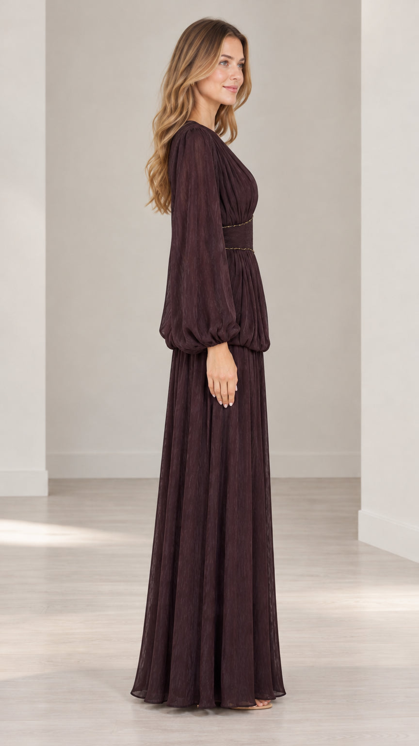 Side profile view of burgundy pleated evening gown with balloon sleeves