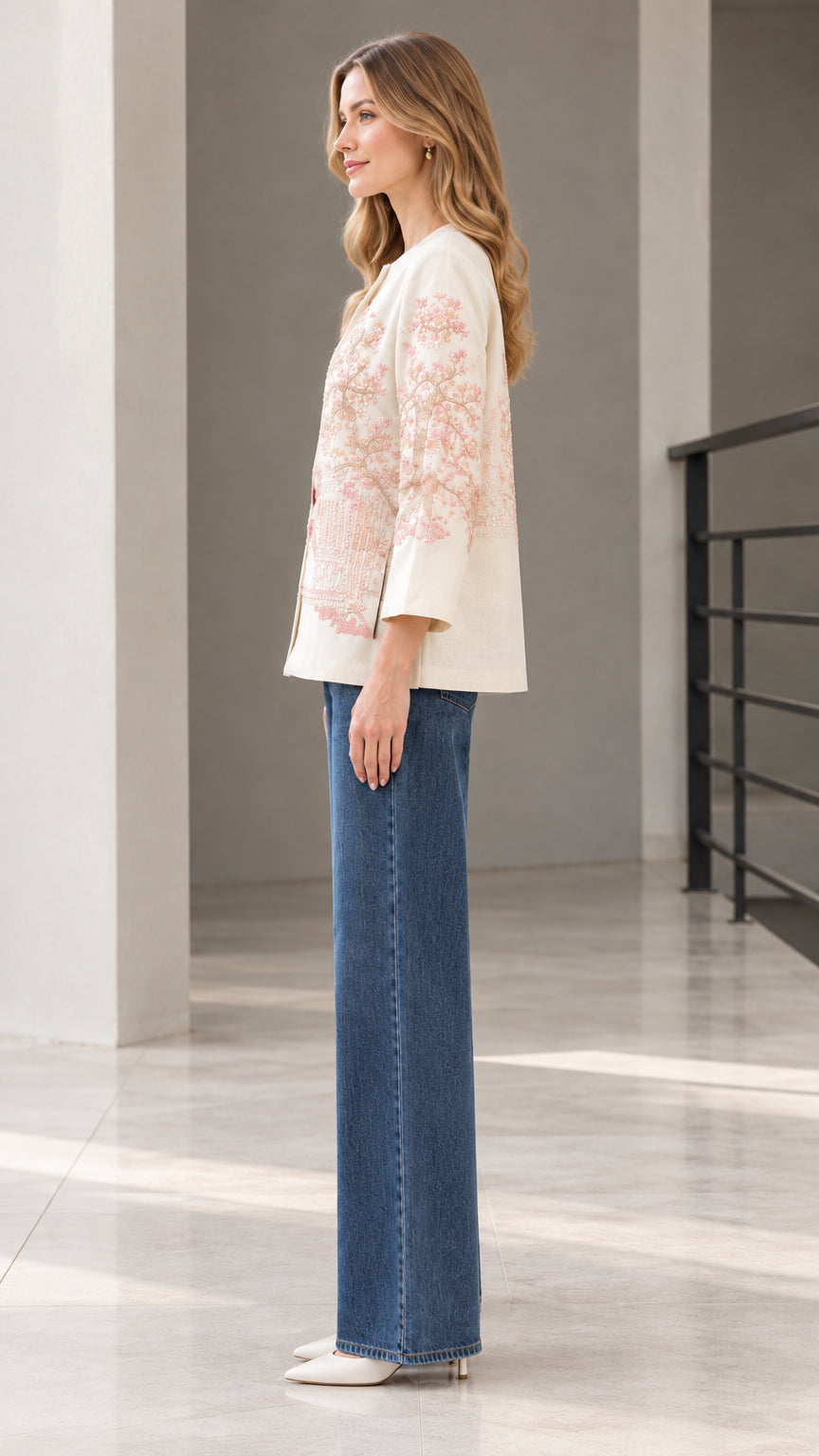 Side profile view of model wearing cream embroidered jacket
