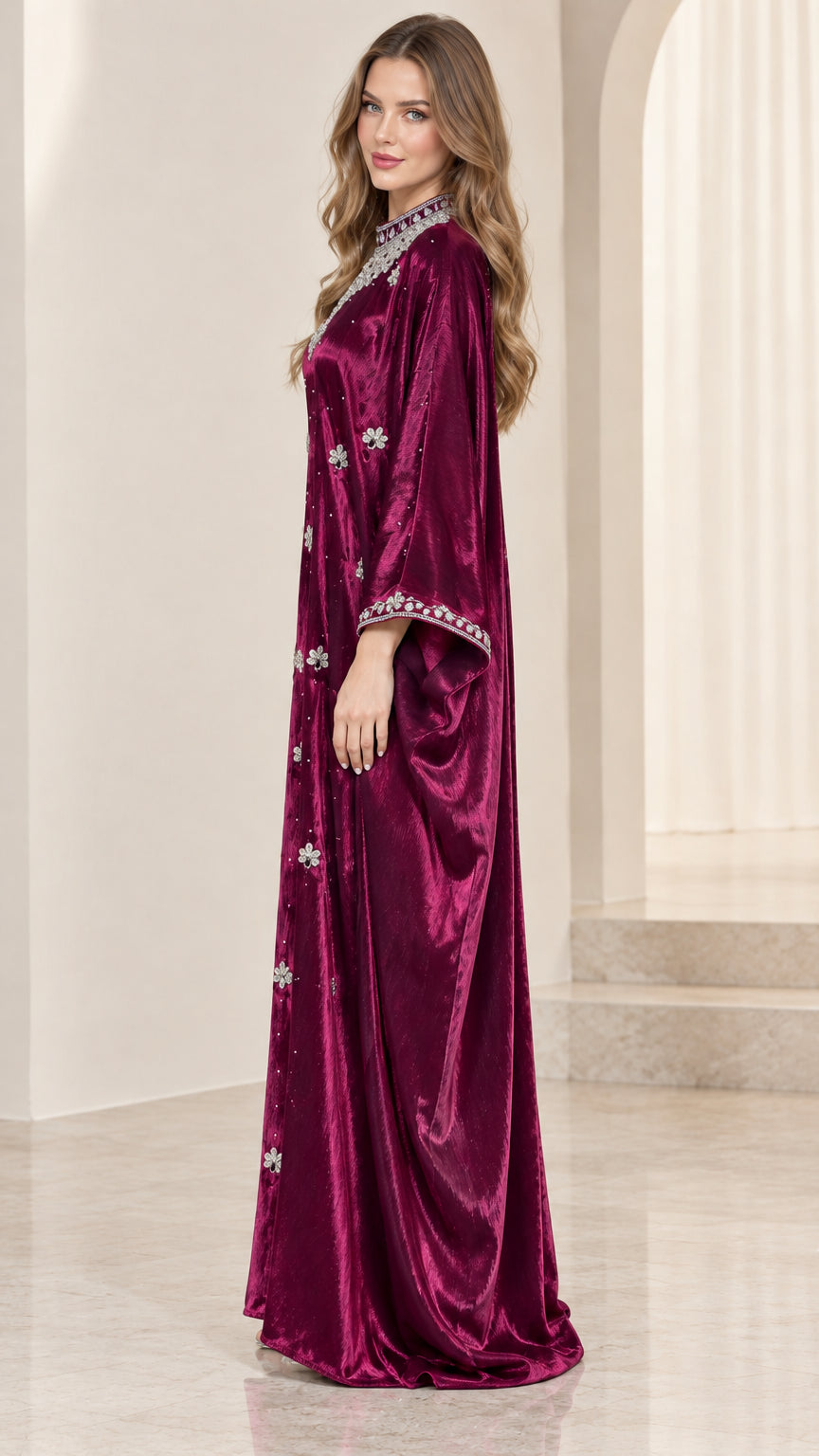 Side profile view of woman modeling flowing burgundy velvet kaftan gown