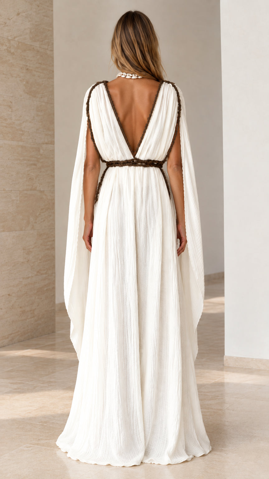 Back view of white maxi dress featuring deep V-back and draped sleeves