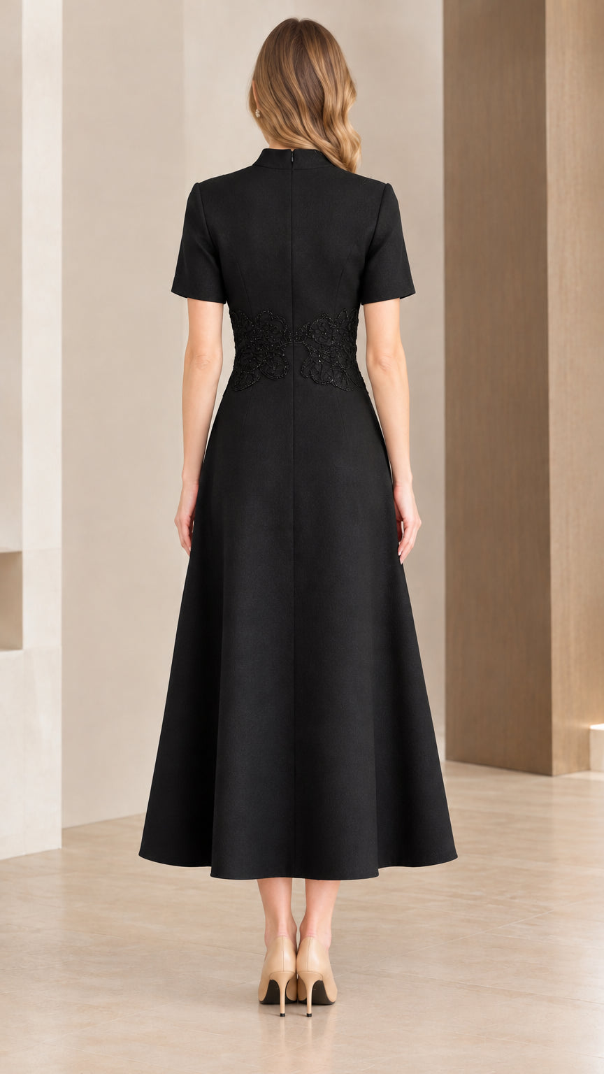 Back view of woman wearing black mock neck midi dress showing clean tailored lines