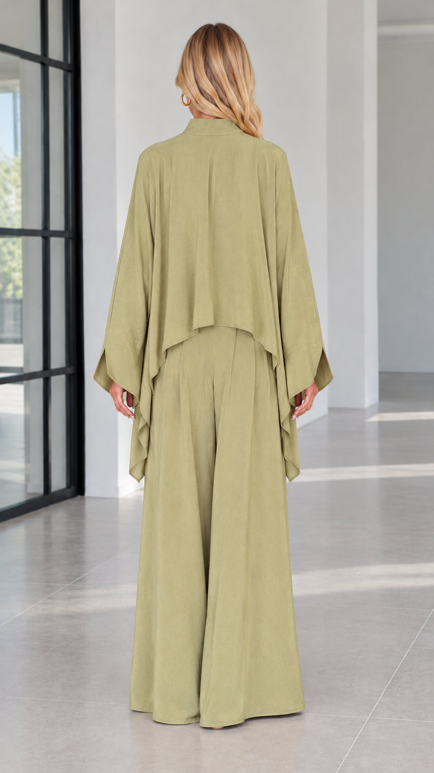 Back view of sage green two piece flowy cape top and wide leg trousers