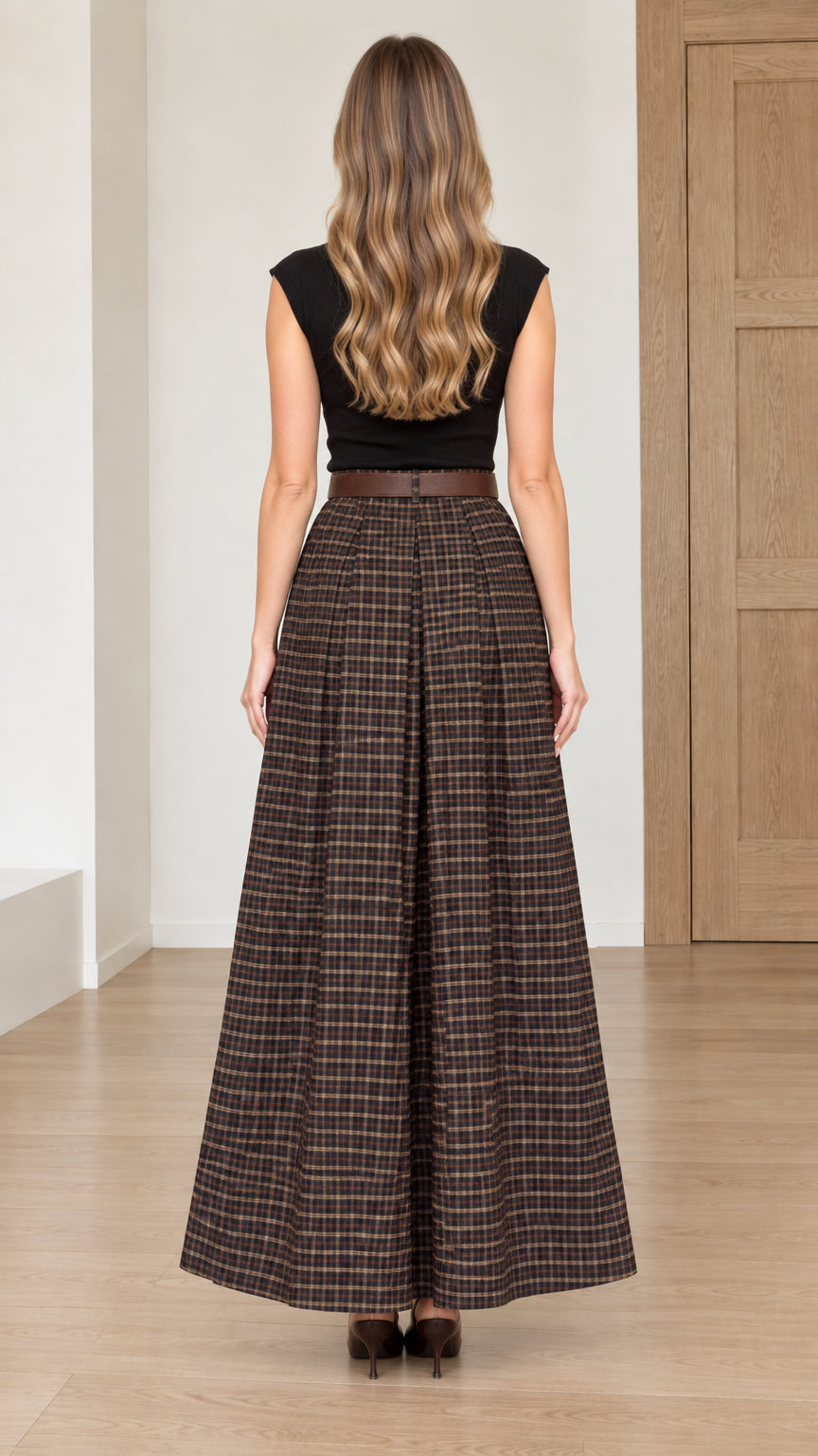 Back view of model wearing long brown plaid pleated maxi skirt