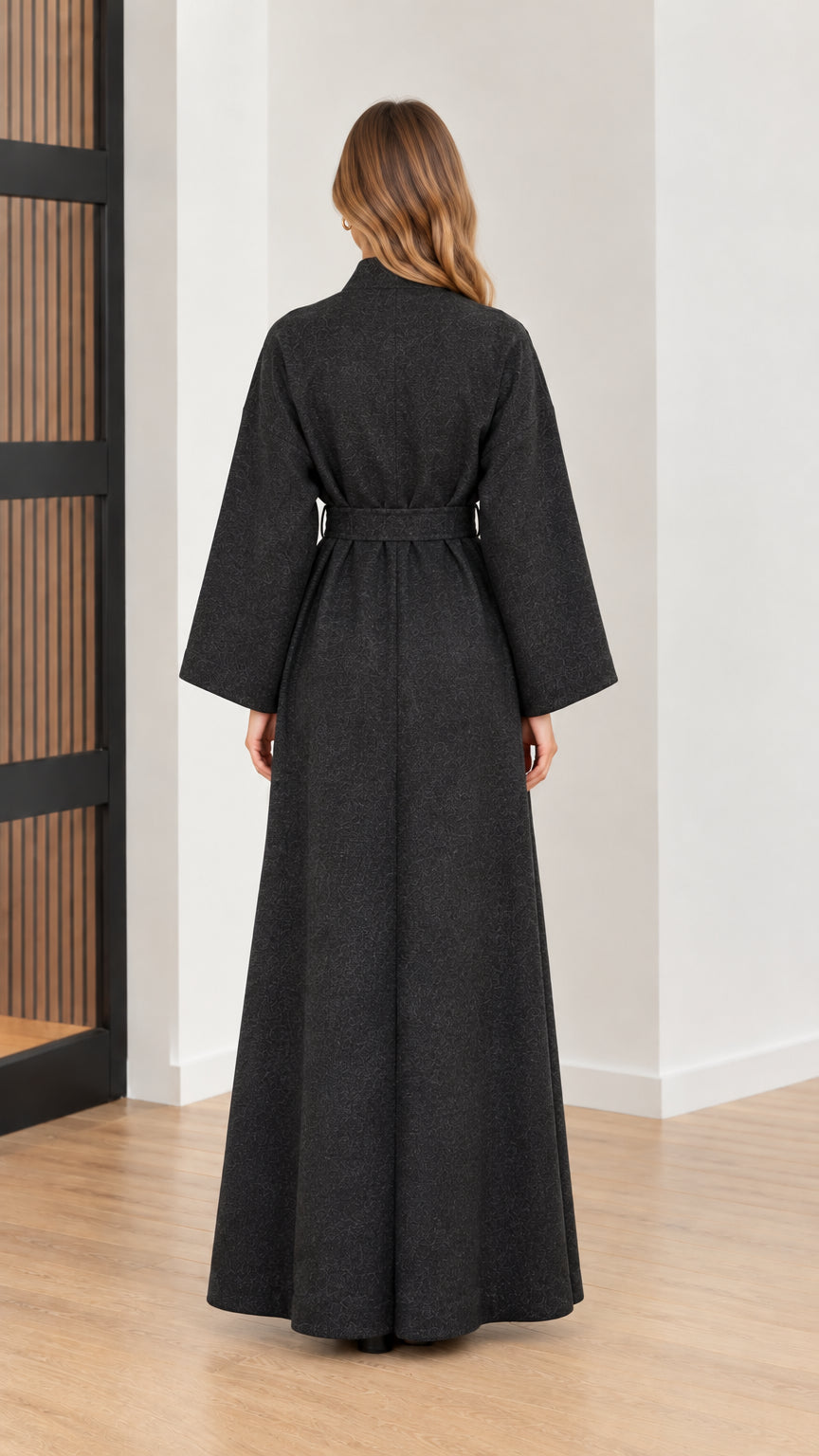 Back view of woman wearing full length charcoal grey tie-waist coat