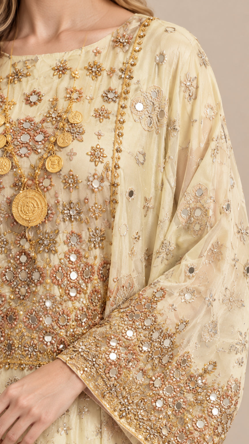 Close-up detail of metallic embroidery, sequins, and coin medallion details on kaftan dress