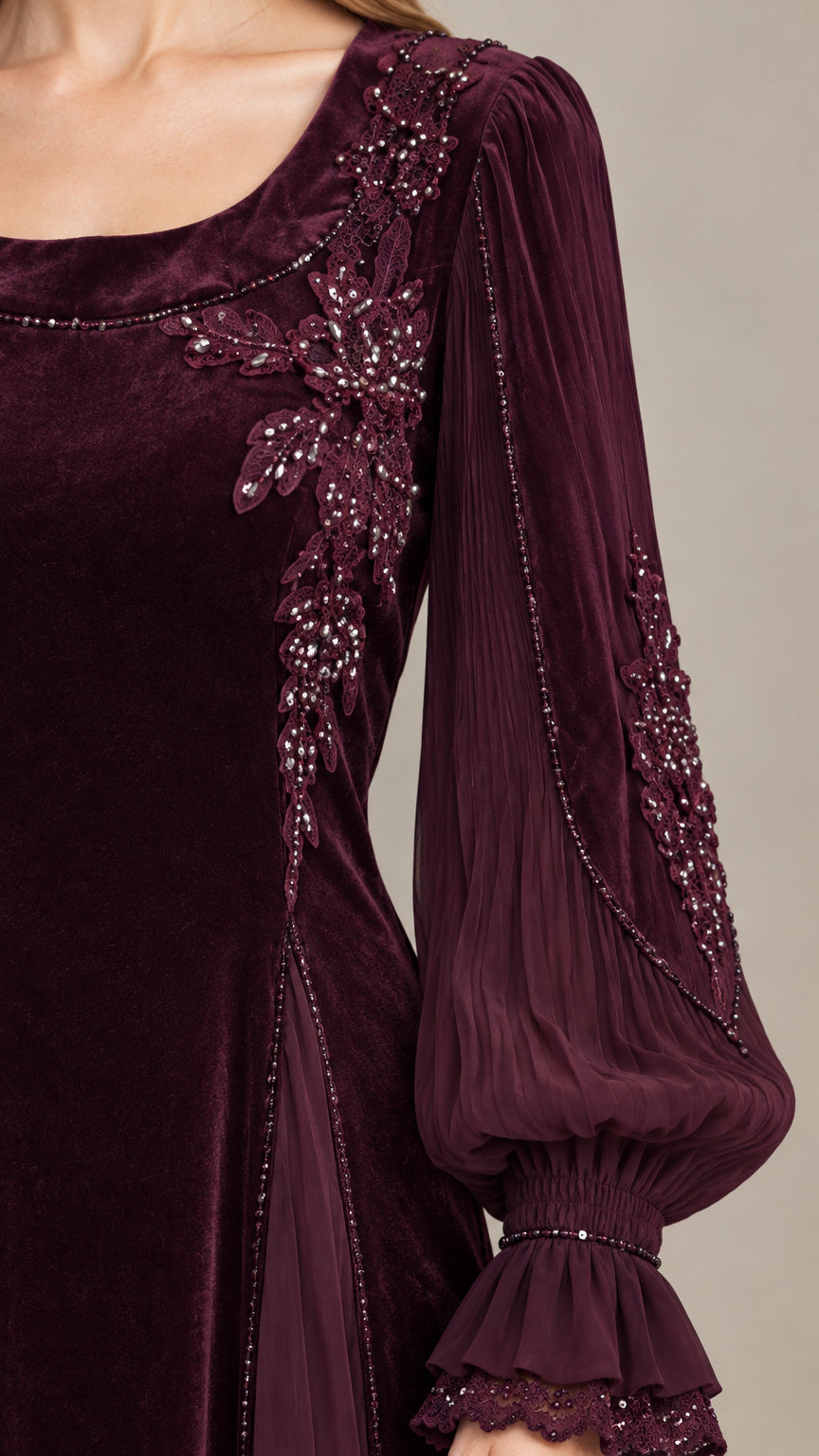 Close-up detail of beaded floral appliqué on velvet neckline and ruffled sleeve cuff
