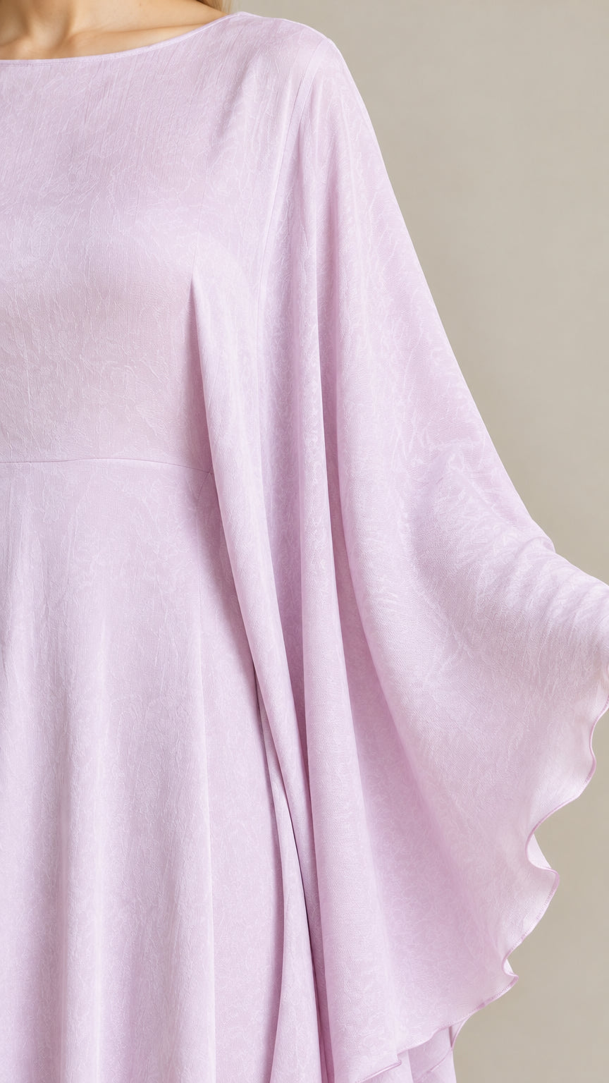 Close-up detail of fabric texture and draped shoulder cape on lavender dress