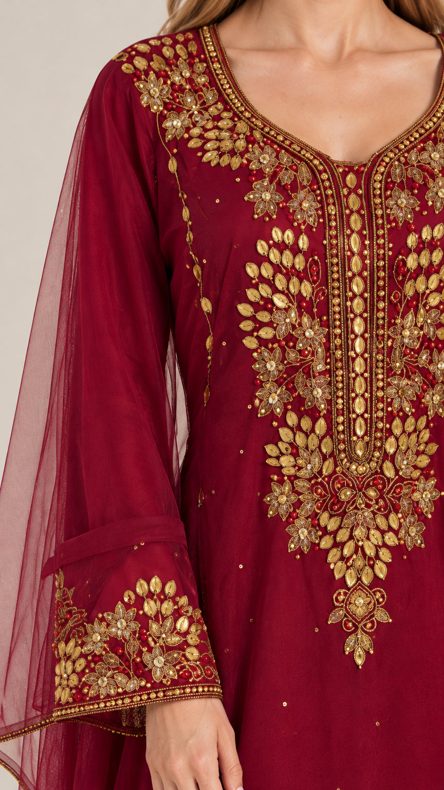 Close-up detail of gold embroidery on burgundy chiffon dress neckline and sleeve