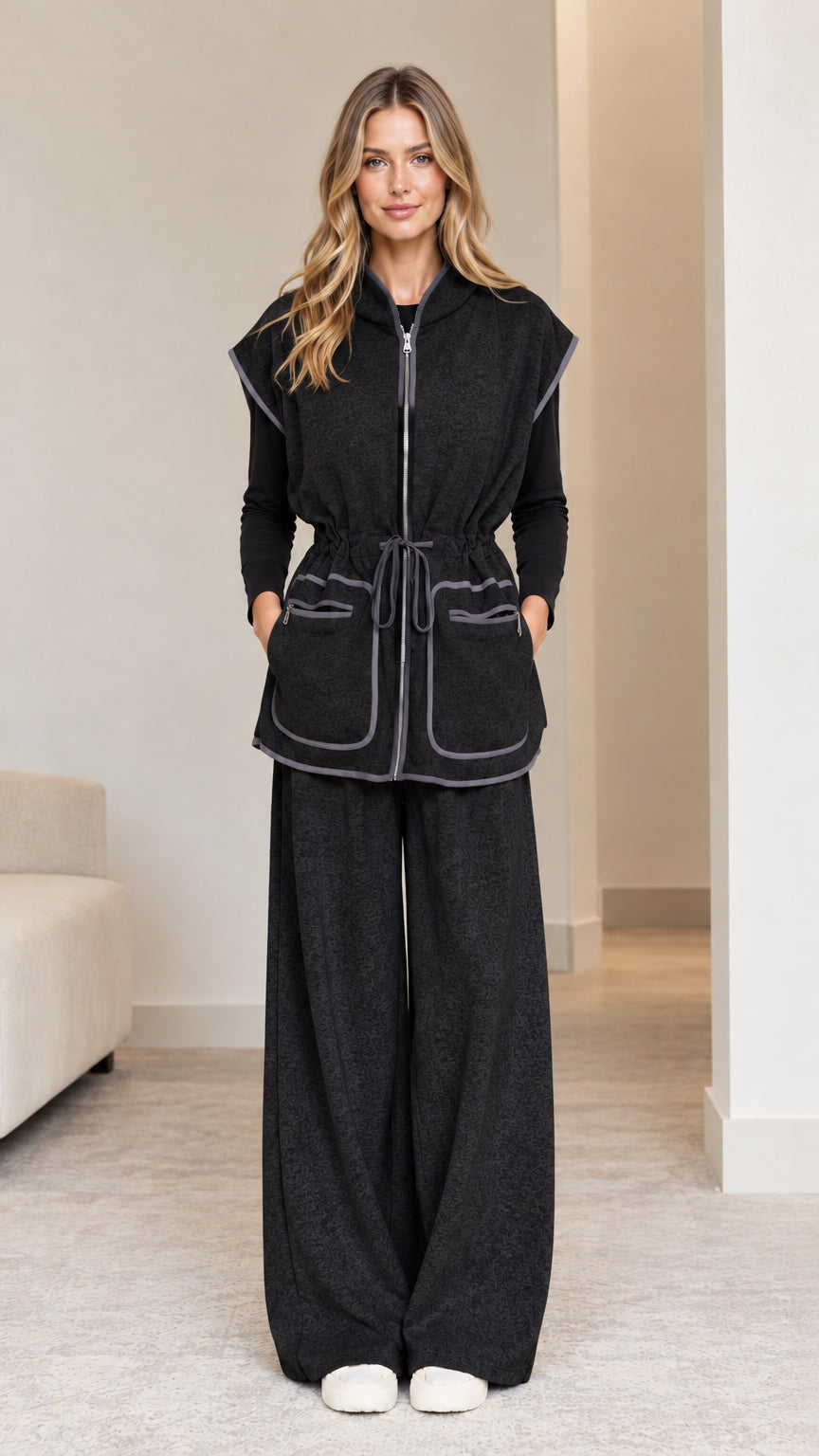 Model wearing black 2-piece hooded vest and wide-leg pants set