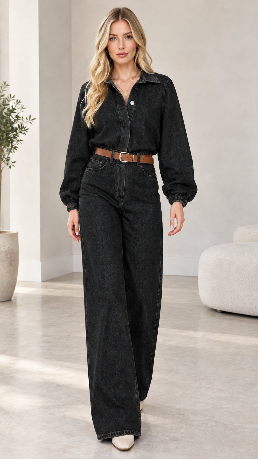 Model wearing washed black wide-leg denim jumpsuit with brown belt