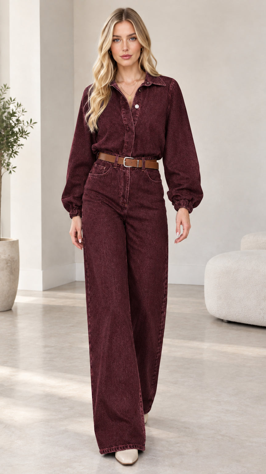 Model wearing burgundy plum wide-leg denim jumpsuit with brown belt